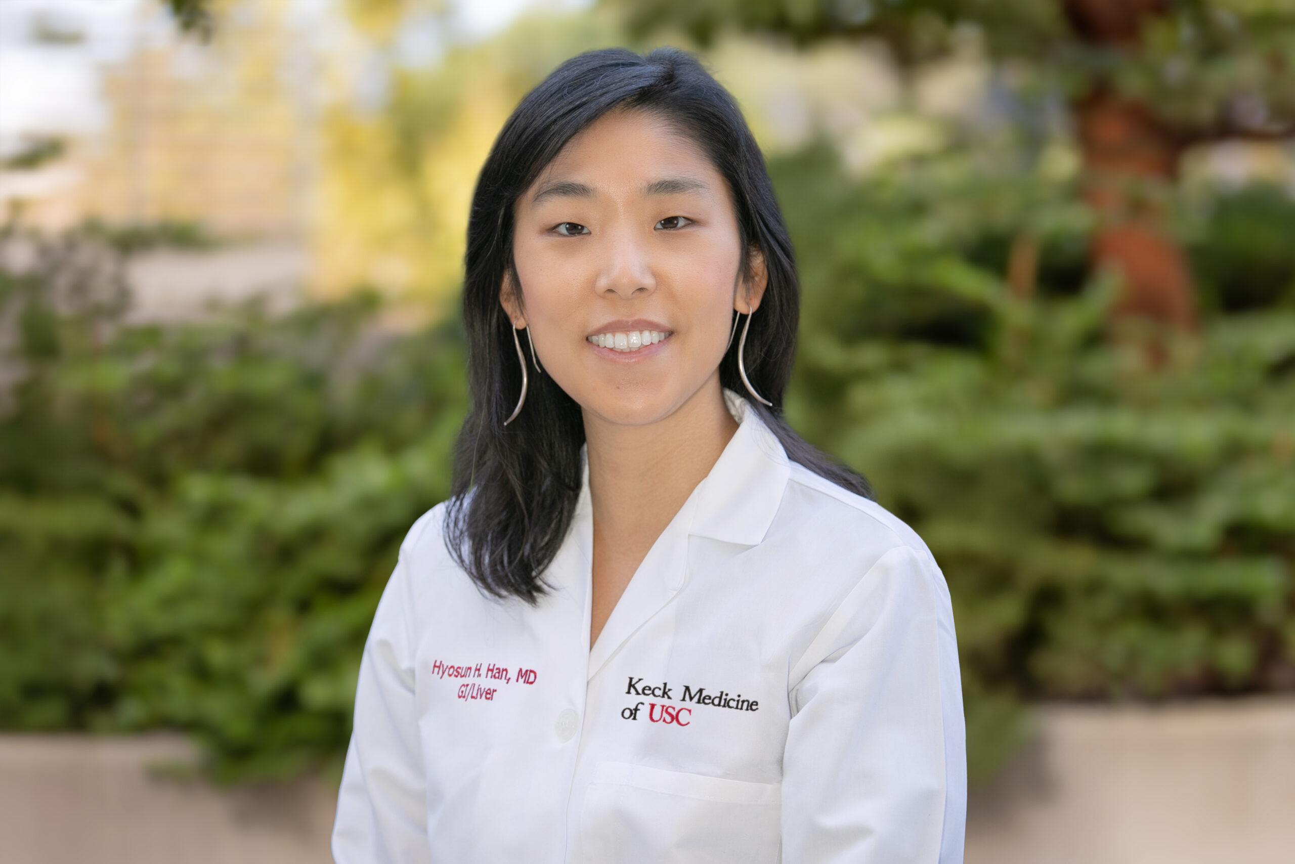 Dr. Helen Han stands outside in a white jacket.