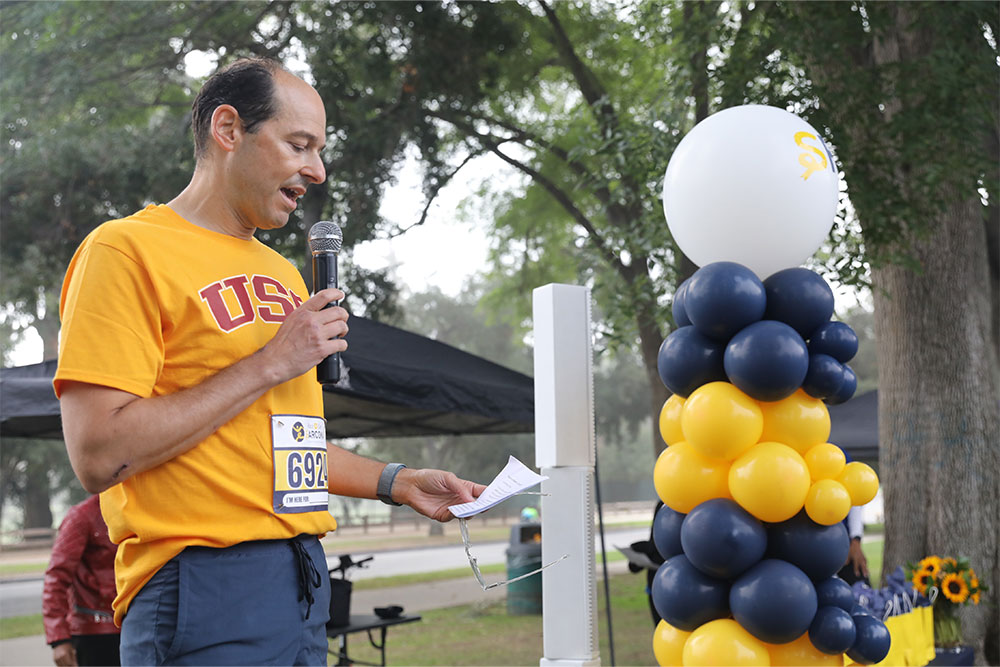 Man talking in front of a balloon arch